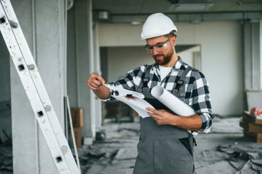 Yönetici planlarını uygulamaya koydu. Üniformalı tamirci tamamlanmamış binada..