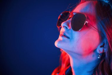 Yan görünüş, göz giysisi. Neon renkli güzel bir kadın portresi..