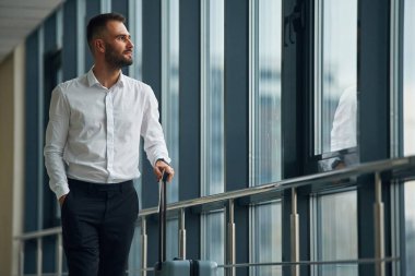 Ayakta dikilip pencereden bakıyordum. Havaalanında genç yakışıklı bir adam var..