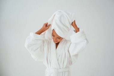 Kafasında havluyla. Güzellik ve özen kavramı. Genç kız stüdyoda..