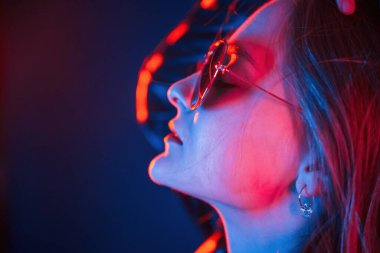 Yan görünüş, göz giysisi. Neon renkli güzel bir kadın portresi..