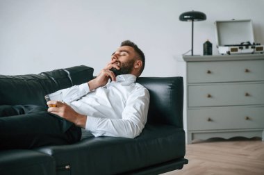 Siyah kanepede. Alkolik genç adam içeride..