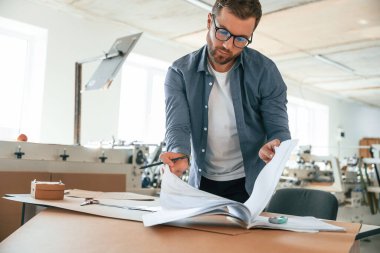 Yakışıklı adam ekolojik kutular üreten fabrikada çalışıyor..