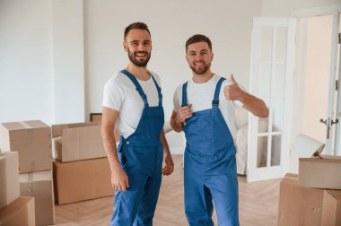 Durup poz vermek. Bir odada hareket eden iki servis çalışanı.