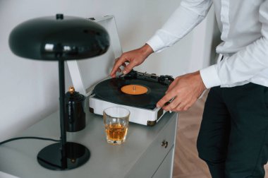 Müzik çalmak için vinil kuruyorum. Alkolik genç adam içeride..