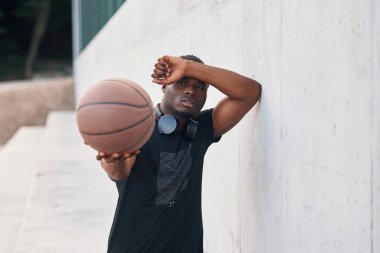 Topu elinde tutuyor. Genç siyah adam.