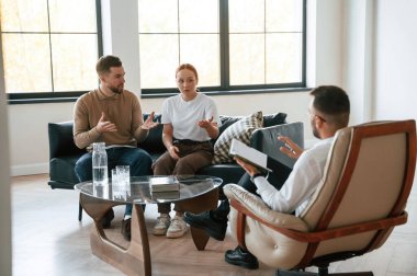 Adam notlar yazıyor. Psikolog randevusundaki çift..