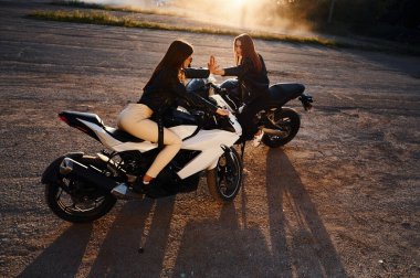 Güzel gün ışığında. Motosikletli iki kadın dışarıda birlikteler..