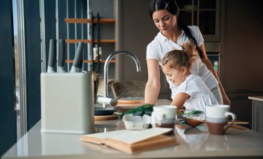 Öğrenme süreci. Anne ve kızı mutfakta yemek hazırlıyorlar..