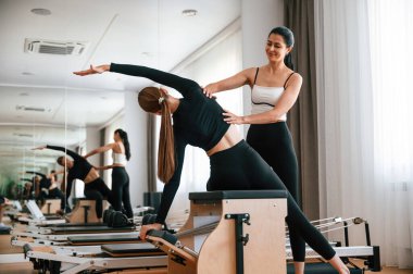 Omurga germeyi öğretiyorum. Spor salonundaki kadınlar egzersiz yapıyor..