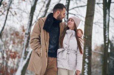 Birbirlerine bakıyorlar. Güzel bir çift kış ormanında yürüyüşe çıktı..