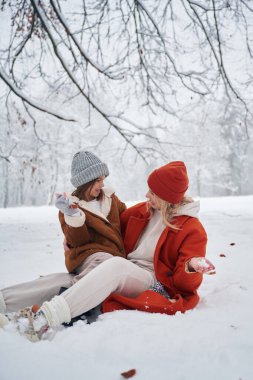 Karda. Anne ve kızı kış çayırlarında ve ormandalar..