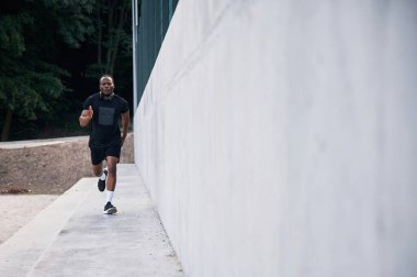 Sportif siyah adam koşuyor, sabah rutini..