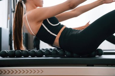 Manzarayı kapat. Spor salonundaki genç kadın egzersiz yapıyor..