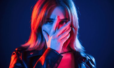 Koyu mavi arka plana karşı. Neon renkli güzel bir kadın portresi..