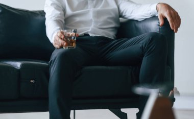 Elde bir bardak viski. Alkolik genç adam içeride..