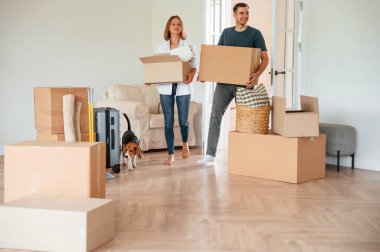 Yeni sahipleri gülümsüyor. Köpekli genç çift yeni evine taşınıyor..