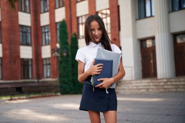 Ön manzara. Okul üniformalı kız binanın yanında..