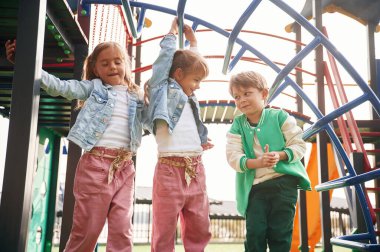 Ön manzara. Çocuklar oyun alanında eğleniyor..