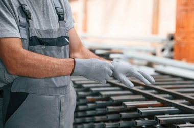 Eldiven takıyordu. Fabrikada çalışan adamın yakın görüntüsü..