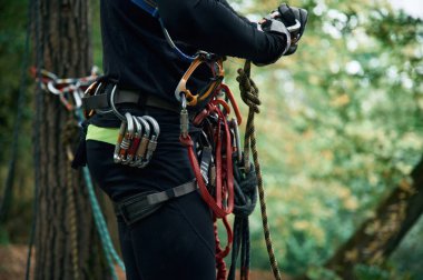 Parçacık görünümünü kapat. İnsanlar ormana tırmanmak için güvenlik ekipmanları kullanıyorlar..