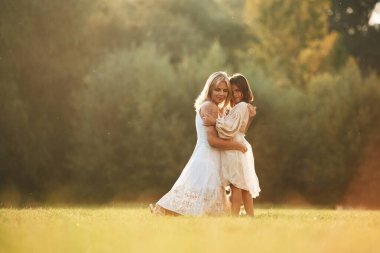 Birbirinize sarılın. Kızıyla birlikte bir kadın yaz tarlasında..