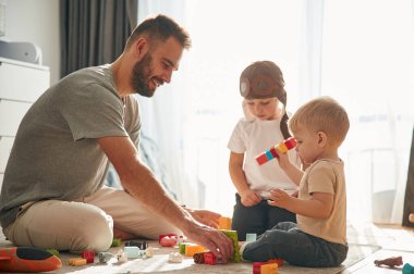 İnşaat oyuncakları. Babam yerde iki küçük çocukla oynuyor..