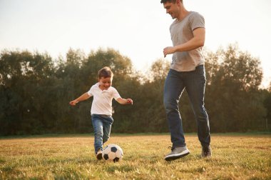 Nasıl futbol oynanacağını öğreniyorum. Baba ve küçük oğlu dışarıda eğleniyorlar..