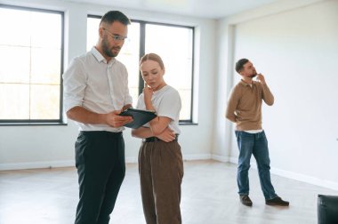 Emlakçı genç bir çifte bir daire gösteriyor..