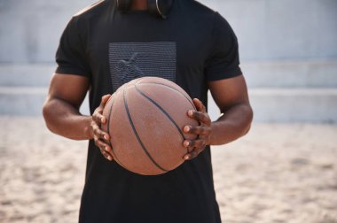 Manzarayı kapat. Genç siyah adam basketbol topuyla dışarıda..