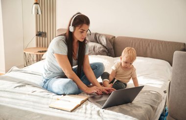 Laptop gösteriliyor. Anne ve küçük oğlu evlerinde, evlerinde..