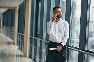 Telefonla konuşuyorum. Havaalanında genç yakışıklı bir adam var..