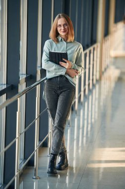 Siyah tabletli mutlu yüz ifadesi. Havaalanındaki genç bayan..