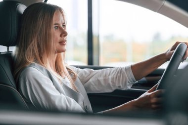 Kadın arabada oturuyor ve onu sürüyor..