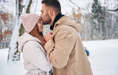Aşk kavramı. Çiftler kış ormanlarında yürüyüşe çıkar..