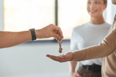 Müşteriler burayı satın aldı, anahtarları aldılar. Emlakçı genç bir çifte bir daire gösteriyor..