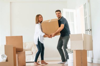 Ağır bir kutuyla. Genç çift yeni evine taşınıyor..