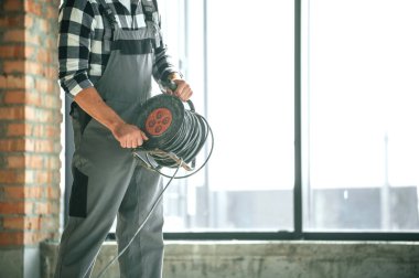 Tamamlanmamış binanın içerisindeki tamircinin yakın görüntüsü.