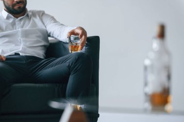 Elde bir bardak viski. Alkolik genç adam içeride..