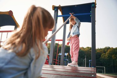 Günlük kıyafetlerle. Çocuklar oyun alanında eğleniyor..