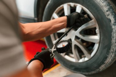 Lastiği ayarlıyorum. Adam otomobil tamirhanesinde çalışıyor..