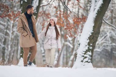 Birbirlerine bakıyorlar. Güzel bir çift kış ormanında yürüyüşe çıktı..