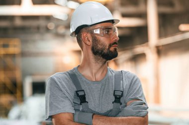 Yakışıklı bir adam. Gri üniformalı genç fabrika işçisi.