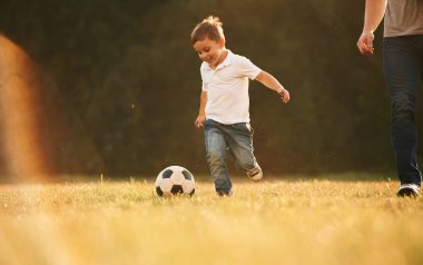 Aktivite, koşmak ve futbol oynamak. Baba ve küçük oğlu dışarıda oynuyor ve eğleniyorlar..