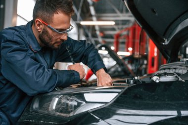 Araba tamircisi otomobille garajda..