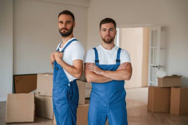 Durup poz vermek. Bir odada hareket eden iki servis çalışanı.