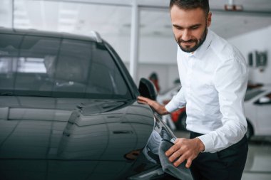 Cilalı yüzeye bakıyorum. Resmi giyinen işçi oto kuaföründe..