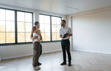 Boş oda. Emlakçı genç bir çifte bir daire gösteriyor..