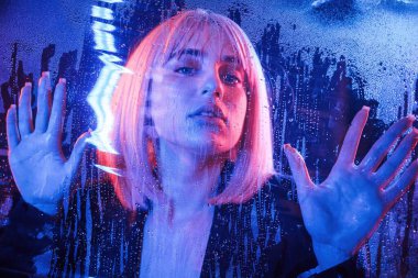 Poz, sakince yüz ifadesi. Beyaz saçlı şık kadın ıslak şeffaf plastik çarşafın arkasında..