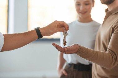 Müşteriler burayı satın aldı, anahtarları aldılar. Emlakçı genç bir çifte bir daire gösteriyor..